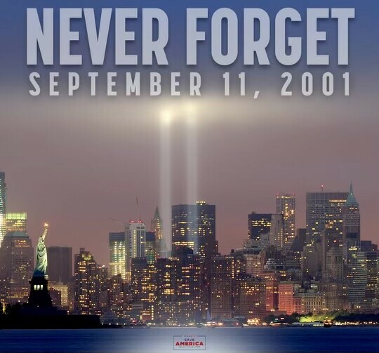Never Forget September 11, 2001. New York City skyline at dusk with the Statue of Liberty in the foreground and the Tribute in Light memorial beams shining where the Twin Towers once stood.