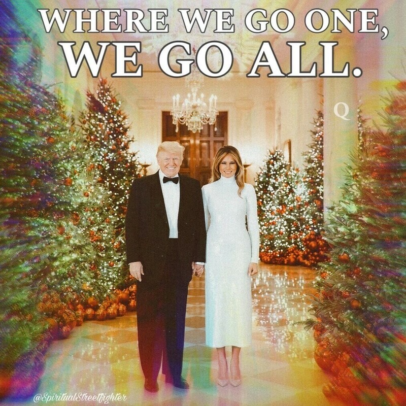A man in a black tuxedo and a woman in a white dress holding hands in a festive, decorated hallway with Christmas trees and ornaments. The text "WHERE WE GO ONE, WE GO ALL" is prominently displayed at the top. A "Q" symbol is positioned on the right side of the image. The bottom left corner features the handle "@SpiritualStreetFighter."