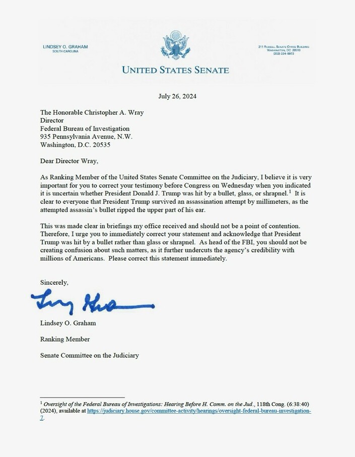 United States Senate letterhead, dated July 26, 2024, addressed to The Honorable Christopher A. Wray, Director of the Federal Bureau of Investigation, from Lindsey O. Graham, Ranking Member of the Senate Committee on the Judiciary. The letter urges Director Wray to correct his testimony before Congress regarding whether President Donald J. Trump was hit by a bullet, glass, or shrapnel during an assassination attempt, emphasizing that it was a bullet. The letter stresses the importance of accurate information for maintaining FBI credibility. Contains official contact information and a reference to the source.