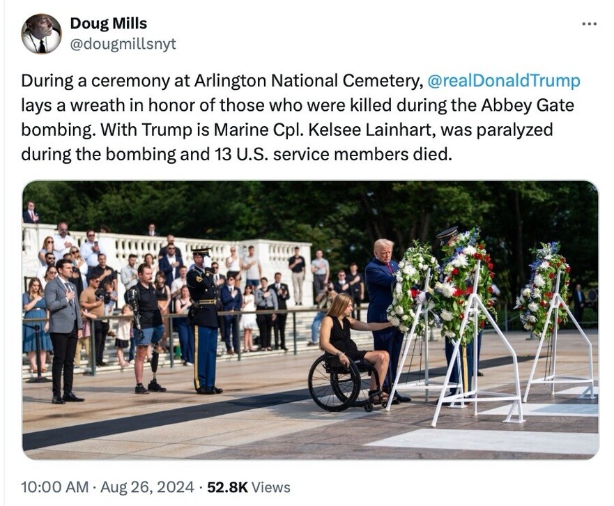 Doug Mills tweet with an image of a ceremony at Arlington National Cemetery where a former U.S. President and Marine Cpl. Kelsee Lainhart, who is in a wheelchair, lay a wreath in honor of the victims of the Abbey Gate bombing. The former President is seen wearing a suit, and there is a crowd of people in the background.