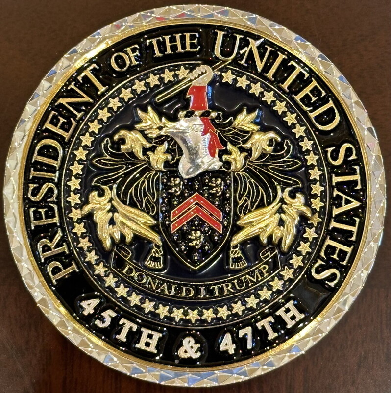 Gold and black decorative emblem with a heraldic crest, featuring an eagle and ornate designs, inscribed with "President of the United States" and "Donald J. Trump, 45th & 47th."