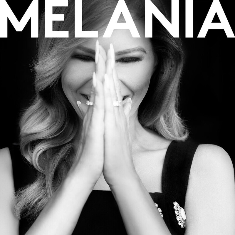 Black and white photo of a woman with medium-length hair, wearing a sleeveless dress adorned with decorative pins, smiling with hands clasped together. The text "MELANIA" is displayed at the top.