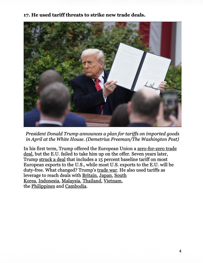 Donald Trump holding a document outdoors while seated at a desk, with people in the foreground and greenery in the background. The setting appears to be a formal announcement event, with some text visible on the document he's holding.